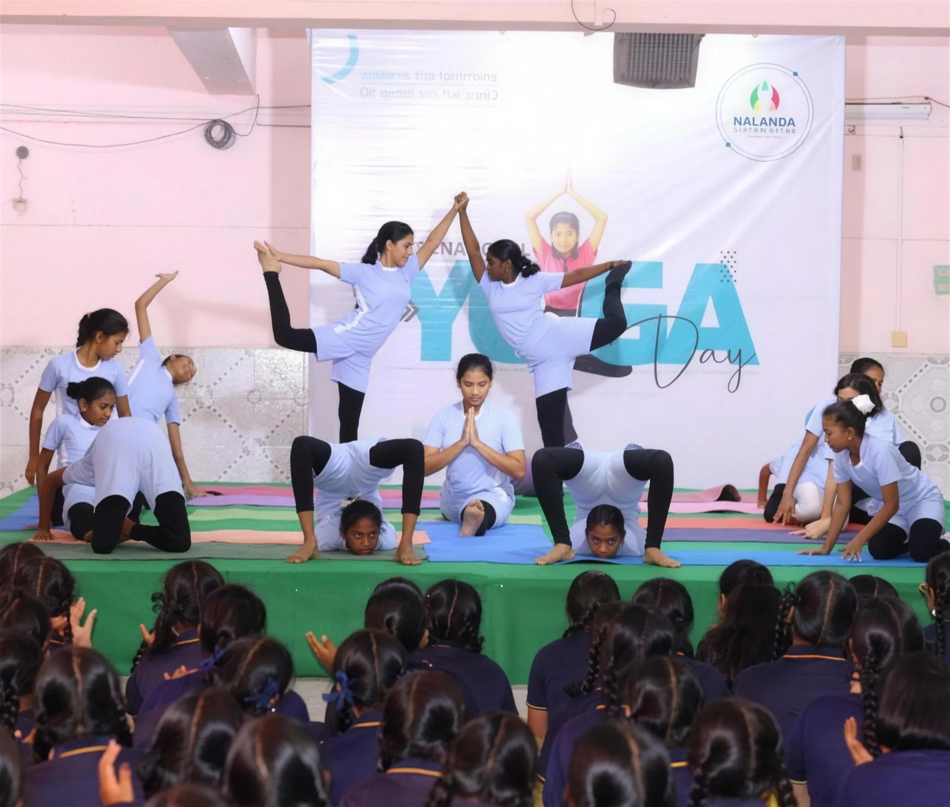 Students performing yoga on stage at a school event